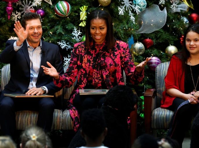 Television personality Ryan Seacrest (L) and U.S. first lady Michelle Obama (C) read 'The Night Before Christmas' as they visit with patients at Children's National Medical Center in Washington, DC, U.S. December 12, 2016. REUTERS/Jonathan Ernst