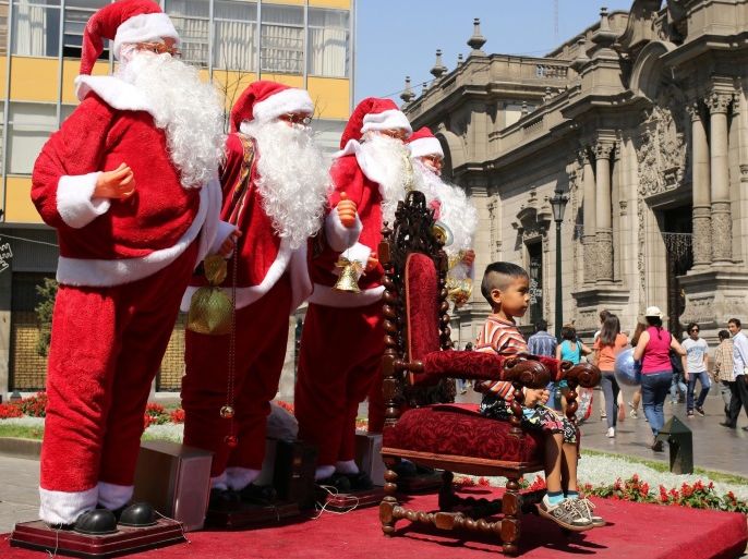 A child poses for a picture with Santa Claus figures, next to the government palace (R), in downtown Lima, Peru, December 11, 2016. REUTERS/Mariana Bazo