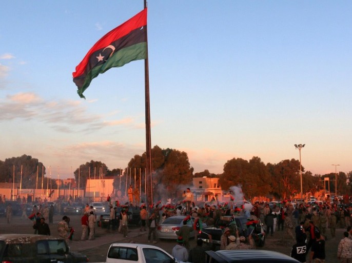A Libyan flag flies as people and Libyan forces celebrate after clearing Ghiza Bahriya, the final district of the group's former stronghold of Sirte, Libya December 6, 2016. REUTERS/Hani Amara