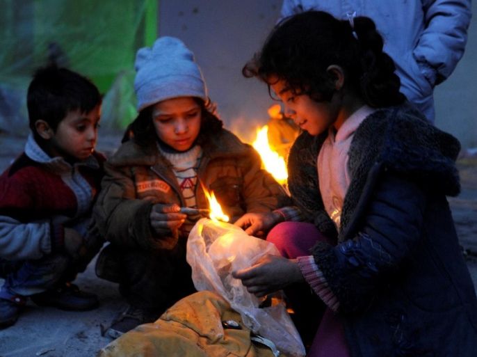 Syrians evacuated from eastern Aleppo, light a fire using plastic bags to keep warm, inside a shelter in government controlled Jibreen area in Aleppo, Syria November 30, 2016. REUTERS/Omar Sanadiki