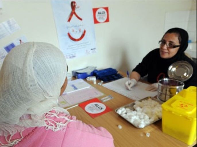 afp : A member (R) of ALCS (Association de lutte contre le sida), an association fighting aids, holds a consultation prior a blood test with a Moroccan woman in Mahammedia near