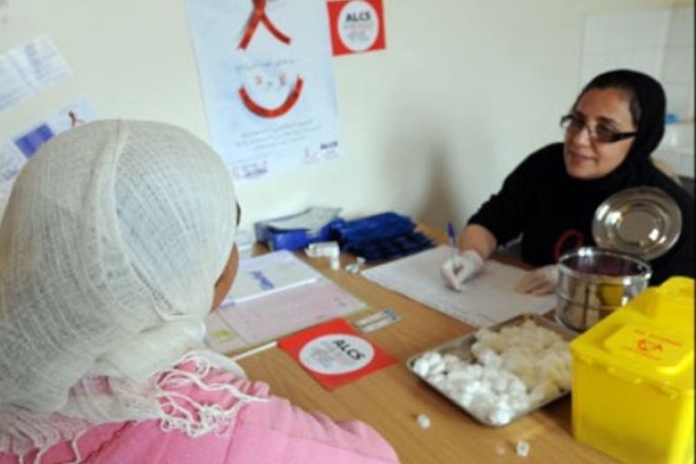 afp : A member (R) of ALCS (Association de lutte contre le sida), an association fighting aids, holds a consultation prior a blood test with a Moroccan woman in Mahammedia near