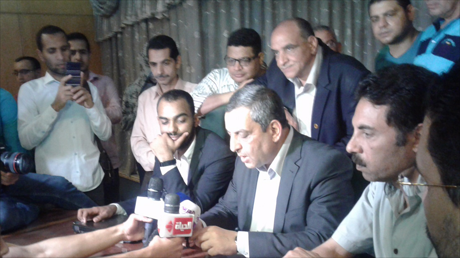 ‪نقيب الصحفيين يحيى قلاش يتوسط أعضاء المجلس أثناء قراءته قرارات الجمعية العمومية للصحفيين‬ (الجزيرة)