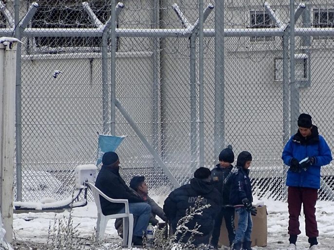A refugee family sits in the snow at the Moria refugees camp on the island of Lesbos, after heavy snowfalls, on 07 January 2017. A cold wave across Greece causing temperatures to drop drastically brought snow fall to many cities of Greece.