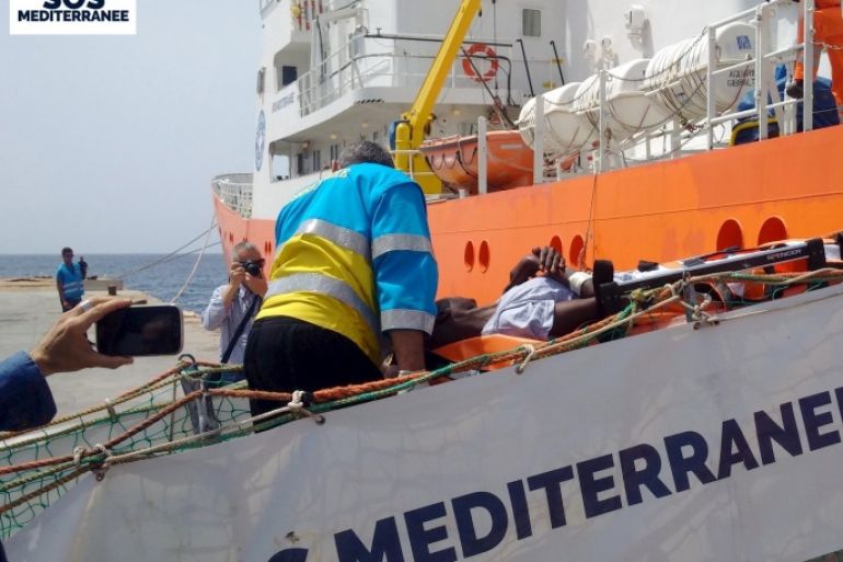A migrant receives help when disembarking from the SOS Mediterranee ship Aquarius at the Italian island of Lampedusa in this handout received April 18, 2016. SOS Mediterranee/Handout via REUTERS ATTENTION EDITORS - THIS IMAGE WAS PROVIDED BY A THIRD PARTY. EDITORIAL USE ONLY. NO RESALES. NO ARCHIVE. REUTERS IS UNABLE TO INDEPENDENTLY VERIFY THIS IMAGE.
