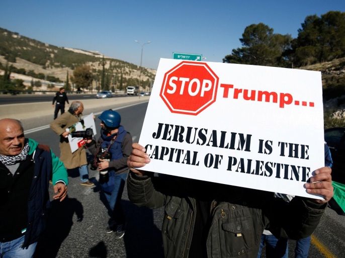 A Palestinian demonstrator holds placard during a protest against a promise by U.S. President-elect Donald Trump to re-locate U.S. embassy to Jerusalem, in the West Bank near Jewish settlement of Maale Adumim, January 20, 2017. REUTERS/Mohamad Torokman
