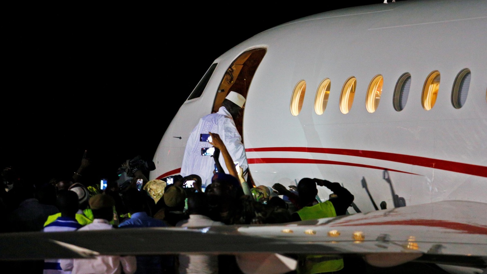 ‪جامي يصعد إلى الطائرة في مطار بانجول إلى منفاه الاختياري في غينيا الاستوائية‬ (رويترز)