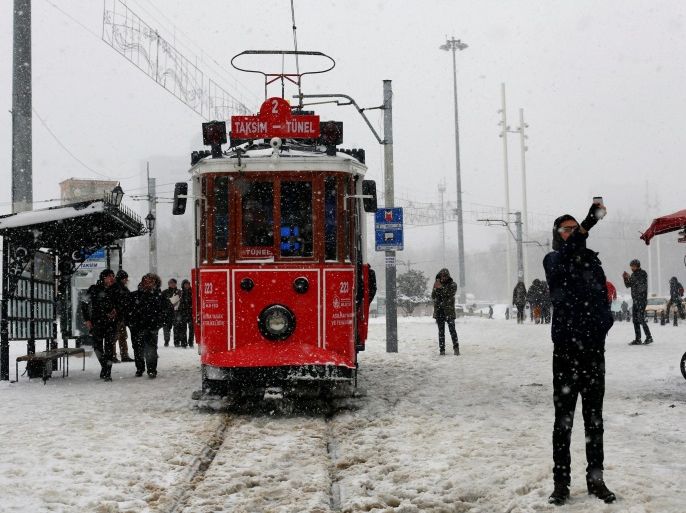 A man takes a selfie with a vintage tram during a snowfall at Taksim square in central Istanbul, Turkey January 7, 2017. REUTERS/Murad Sezer