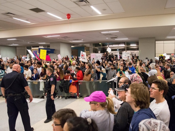 ‪متظاهرون ينددون بقرار ترمب في مطار دالاس الدولي‬ (رويترز)