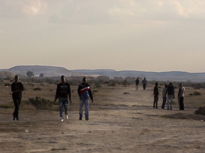 African migrants walking in the desert outside the Holot detention facility in the Negev Desert, in Israel, along the Egyptian border, 02 December 2015. Israel media reports that the center is the fullest it has ever been, housing some 2,500 asylum seekers mainly from Eritrea and Sudan. Hundreds more are expected to be sent there by Israeli authorities in the coming weeks. The detention center allows prisoners to be outside, but they must report back several times and