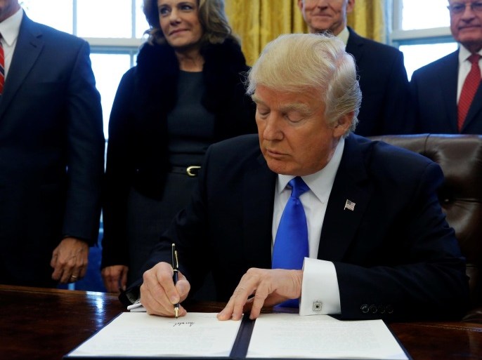 U.S. President Donald Trump signs an executive order dealing with members of the administration lobbying foreign governments, in the Oval Office at the White House in Washington, U.S. January 28, 2017. REUTERS/Jonathan Ernst