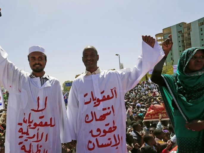 Supporters of Sudan's President Omar Hassan Ahmad al-Bashir wearing Sudanese Jalabiya react during a National Dialogue campaign event in Khartoum February 8, 2016. The Arabic words on the clothings read: "No to American sanctions" (L) and "Sanctions violation to human rights". REUTERS/Mohamed Nureldin Abdallah