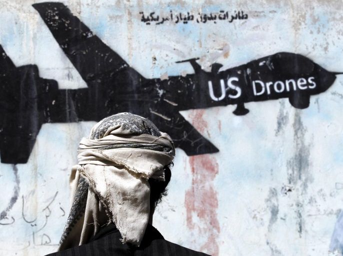 epaselect epa05759688 A Yemeni stands in front of a graffiti protesting US military operations in war-affected Yemen, in Sana'a, Yemen, 29 January 2017. According to reports, US Special Forces troops allegedly disembarked from US helicopters in the Yemeni town of Yakla and attacked several houses belonging to members of the terrorist group Al-Qaeda, killing three high-ranking Al-Qaeda members and nine civilians, six women and three children. One American serviceman has