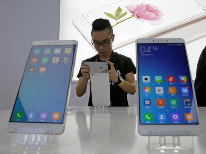 A journalist takes a picture of China's mobile company Xiaomi's new model Mi Max at its launching ceremony in Beijing, China May 10, 2016. REUTERS/Kim Kyung-Hoon