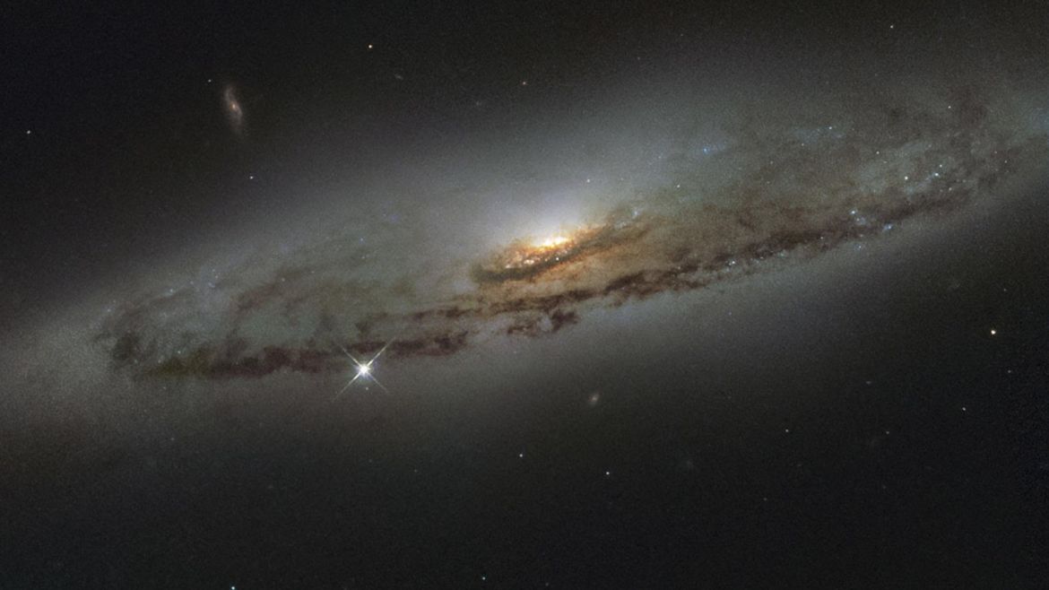 The spiral galaxy NGC 4845, located over 65 million light-years away in the constellation of Virgo (The Virgin) is shown in this NASA/ESA Hubble Space Telescope image released on January 8, 2016. The galaxy�s orientation clearly reveals the galaxy�s striking spiral structure: a flat and dust-mottled disc surrounding a bright galactic bulge. NGC 4845�s glowing center hosts a gigantic version of a black hole, known as a supermassive black hole. REUTERS/NASA/Handout  FOR E