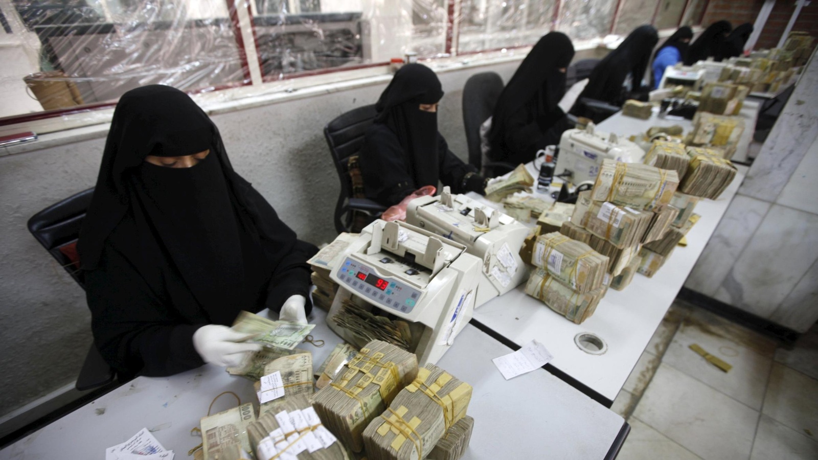‪موظفات يحصين أوراقا نقدية في مقر البنك المركزي بصنعاء والذي نقل إلى عدن‬ (رويترز)