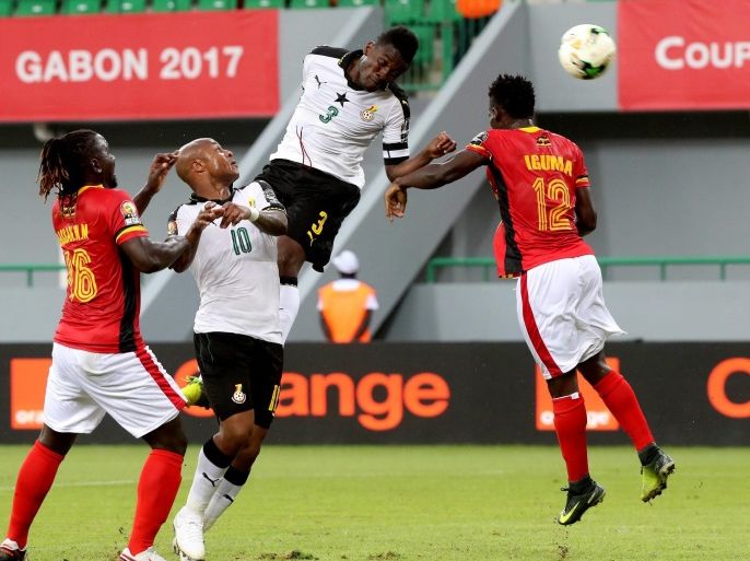Asamoah Gyan of Ghana (cr) wins a header Denis Iguma of Uganda (r) as Hassan Wasswa of Uganda (l) and Andre Ayew (cl) of Ghana look on during the 2017 Africa Cup of Nations match between Ghana and Uganda at the Port Gentil Stadium in Gabon on 17 January 2017.