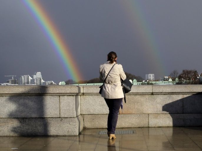 A woman looks towards a double rainbow from Putney Bridge in London March 28, 2016. REUTERS/Kevin Coombs