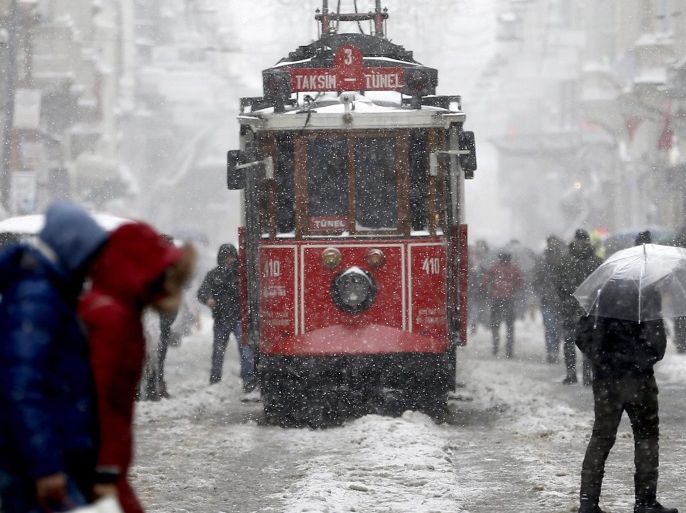 People walk on Istiklal Street while tram passing on a snowy day in Istanbul, Turkey, 07 January 2017. Temperatures in Istanbul dropped to minus five degrees Celsius with snow showers.