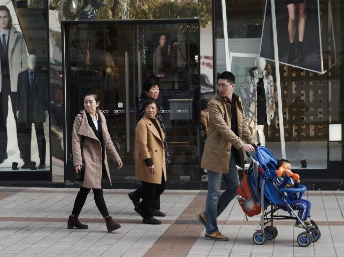 A Chinese family walks past a clothing store in Wangfujing district in Beijing, China, 04 November 2016. China's middle class will be more than one-third of the mainland population by the year 2030, with consumer spending being on the level now seen in the European Union, according to recent data released by analytics company called The Economist Intelligence Unit. About 35 per cent of the population will have approximately 10,000 US-dollars of annual disposable income