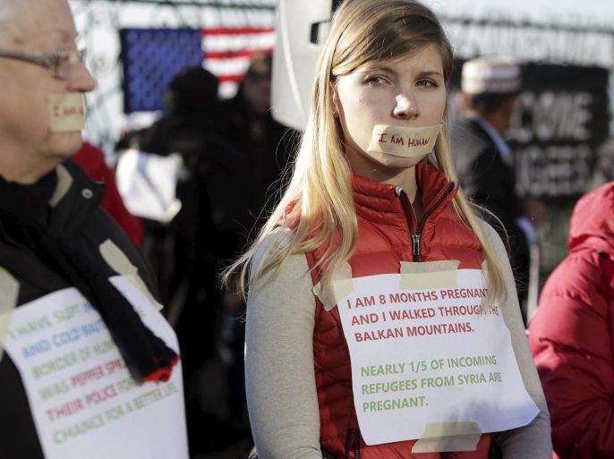 Women wearing tape over their mouths that read "I am human", take part in at a pro-refugee protest organized by Americans for Refugees and Immigrants in Seattle, Washington November 28, 2015. REUTERS/Jason Redmond