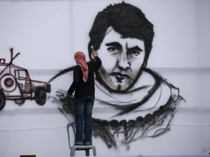 A Palestinian paints a picture of late Hamas bomb maker Yahya Ayyash during a Hamas rally in Khan Younis in the southern Gaza Strip January 7, 2016. The rally, organized by Hamas movement, was held to honor the families of dead Hamas militants, who Hamas's armed wing said participated in imprisoning Israeli soldier Gilad Shalit, organizers said. Shalt was abducted by militants in a cross-border raid in 2006, and was released in exchange for more than 1,000 Palestinians held in Israeli jails. REUTERS/Mohammed Salem FOR EDITORIAL USE ONLY. NO RESALES. NO ARCHIVE.