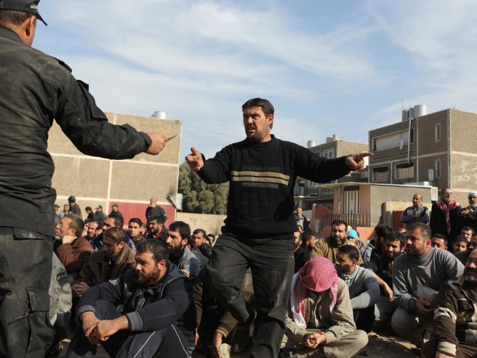  رجال المخابرات يتفحصون هويات أشخاص بالموصل بحثا عن مقاتلي تنظيم الدولة (رويترز)