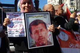 فلسطين رام الله شباط 2016 زوجة نائل البرغوثي تحمل صورته خلال مظاهرة تطالب بالإفراج عن الأسرى