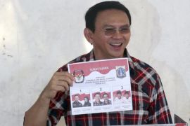 Basuki 'Ahok' Tjahaja Purnama (L), the current governor of Jakarta up for re-election, shows his ballot paper before putting it in a ballot box during regional elections in Jakarta, Indonesia, 15 February 2017. Around 33 provinces in Indonesia hold elections to vote for governors and district leaders on 15 February 2017.