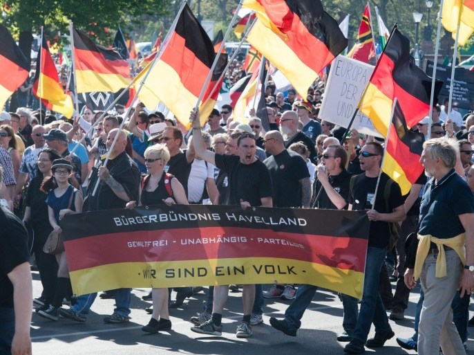 Participants in a march of right-wing groups walk past the Federal Chancellery and carry a banner written with 'Citizen's Alliance Havelland - non-violent, independent, partyless - We are one people' in Berlin, Germany, 07 May 2016. The right-wing populist movement 'Wir fuer Berlin & Wir fuer Deutschland' (We for Berlin & We for Germany) called for a demonstration with the slogan 'Merkel must go.' Multiple alliances of citizens' and left-wing groups and parties