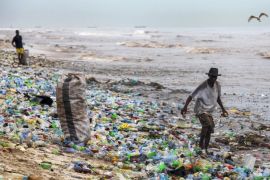 epaselect epa05361332 A photograph made availavble 13 June 2016 shows a Ghanaian collecting recyclable material at the polluted Korle Gono beach, that is covered in plastic bottles and other items washed ashore, following weeks of heavy flooding in Accra, Ghana 12 June 2016. The recyclable materials were washed from the capital Accra through the Korle lagoon ending up at the beach. Waste pollution is a continuing problem in Ghana.
