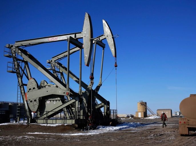 A man walks onto an oil drilling pump site in McKenzie County outside of Williston, North Dakota in this file photo from March 12, 2013. Several counties in North Dakota's Bakken formation and the Eagle Ford and Permian Basin of Texas have seen rig deployments or applications for new well permits drop in half, as energy companies are quickly steering drilling rigs away from marginal areas and focusing on sweet spots of U.S. shale oil fields. REUTERS/Shannon Stapleton/