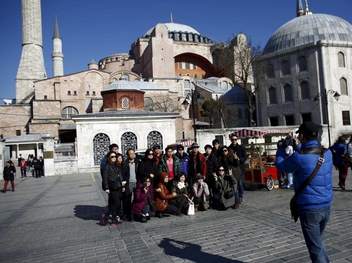 A tourist group from South Korea pose for a souvenir photo with the Byzantine-era monument of Hagia Sophia in Istanbul, Turkey February 9, 2016. TUI Group, the world's largest tour operator, reported a 40 percent drop in bookings to Turkey this summer due to safety concerns and said it was investing in Cape Verde and Bulgaria as alternatives to security-threatened North Africa. Turkey is especially popular with German tourists, but has seen demand slump after a suicide