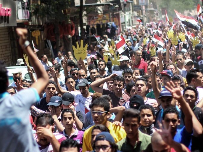 Egyptians, making the four fingered salute associated with the Government massacre of peaceful protesters supporting the now banned Muslim Brotherhood, mark the second anniversary of Rabaa massacre, Giza, Egypt. 14 August 2015. According to reports violent clashes have broken out between protesters and police during events marking the massacre by the Egyptian security forces of at least 800 peaceful supporters of the former Muslim Brotherhood President, Mohamed Morsi, during sit-ins in the Rabaa al-Adawiya and al-Nahda squares 14 August 2013 following Morsi's ouster by the army.