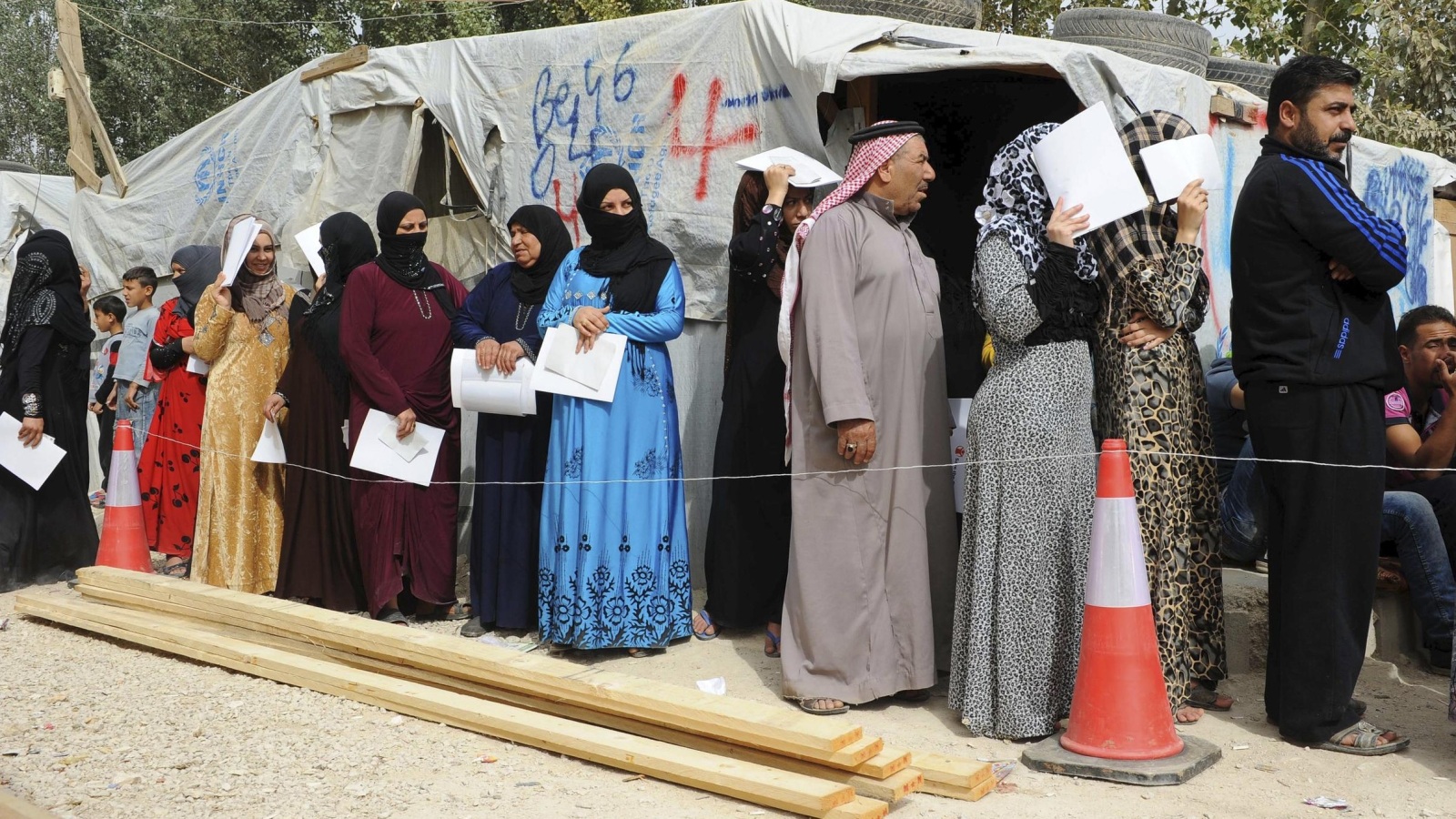 ‪لاجئون سوريون في طابور لتلقي المساعدات في مخيم بوادي البقاع اللبناني‬ (رويترز)