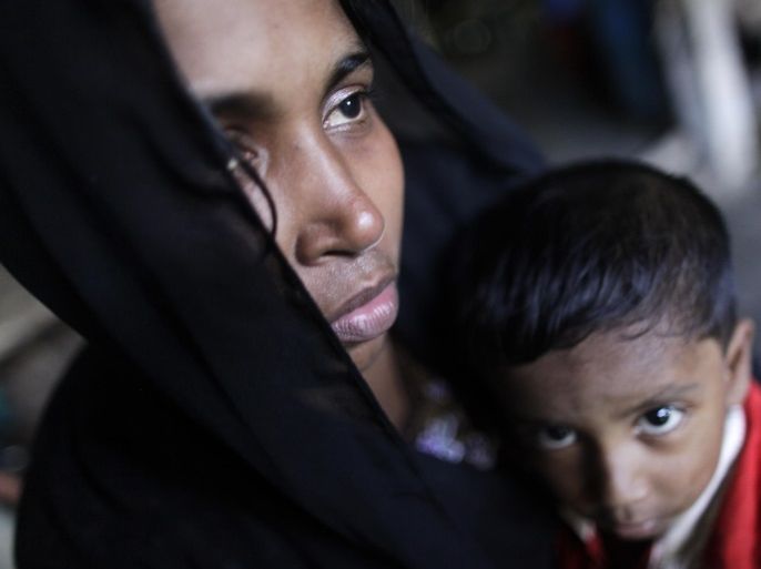 Noor Begum, 23, sits with her child Muhammad Umair in a house as she hides with other relatives in Teknaf October 31, 2012. Noor, who belongs to a group of Rohingya Muslims is currently hiding with local villagers to avoid being arrested by border guards of Bangladesh. She claims that she was raped by five Rakhain men during the sectarian violence in Myanmar. Noor's husband Hasu Miya, 30, was killed by the Myanmar military. According to her, Noor and her family had to pay ten thousand taka each to the agent to get into neighbouring Bangladesh after fleeing the mass burning of houses and violence in Myanmar. REUTERS/Andrew Biraj (BANGLADESH - Tags: SOCIETY IMMIGRATION POLITICS CIVIL UNREST)