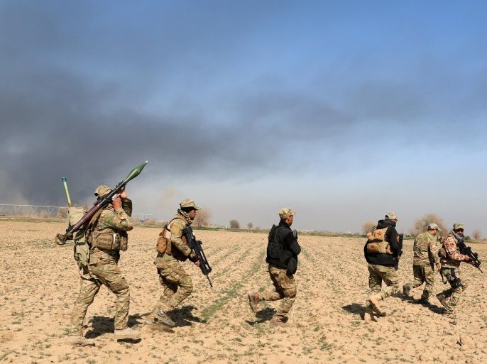 Rapid Response forces members cross farm land during a battle with Islamic State's militants south west of Mosul, Iraq February 24, 2017. REUTERS/Zohra Bensemra
