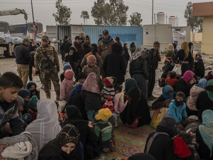 ‪(غيتي)‬ نساء وأطفال نازحون بانتظار تسجيلهم بأحد المخيمات