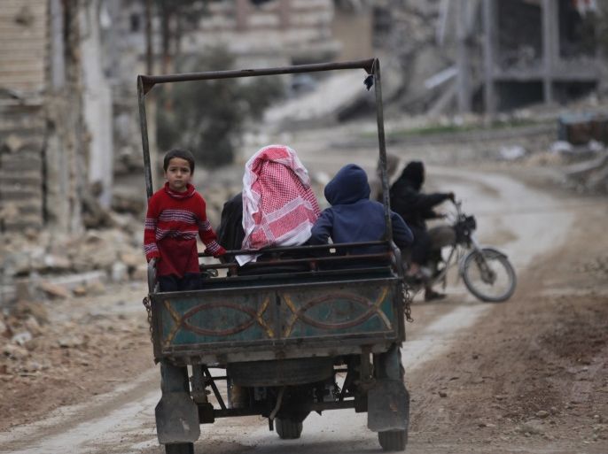 People drive a vehicle through a damaged neighbourhood in the northern Syrian city of al-Bab, Syria March 13, 2017. REUTERS/Khalil Ashawi