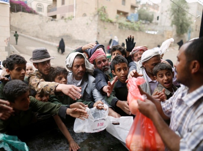 People gather to collect food rations at a food distribution center in Sanaa, Yemen March 21, 2017. REUTERS/Khaled Abdullah