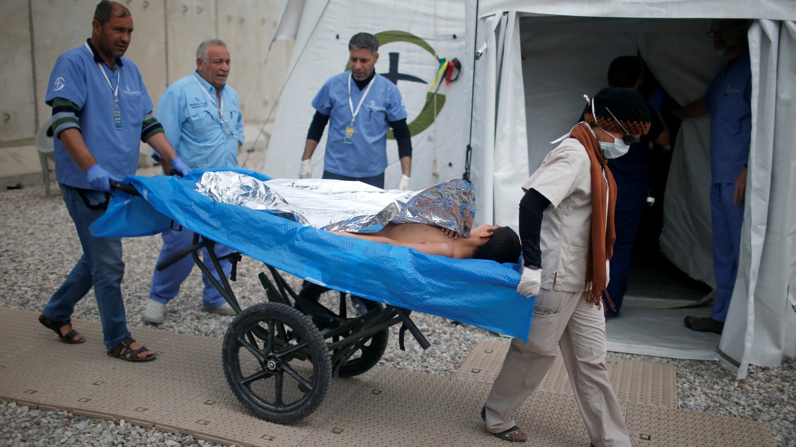 جريح عراقي يُنقل إلى مستشفى ميداني في الموصل (رويترز)