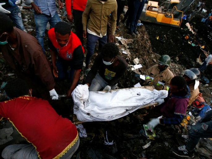 Rescue workers carry the body of a victim recovered out from a pile of garbage following a landslide when a mound of trash collapsed on an informal settlement at the Koshe garbage dump in Ethiopia's capital Addis Ababa, March 13, 2017. REUTERS/Tiksa Negeri