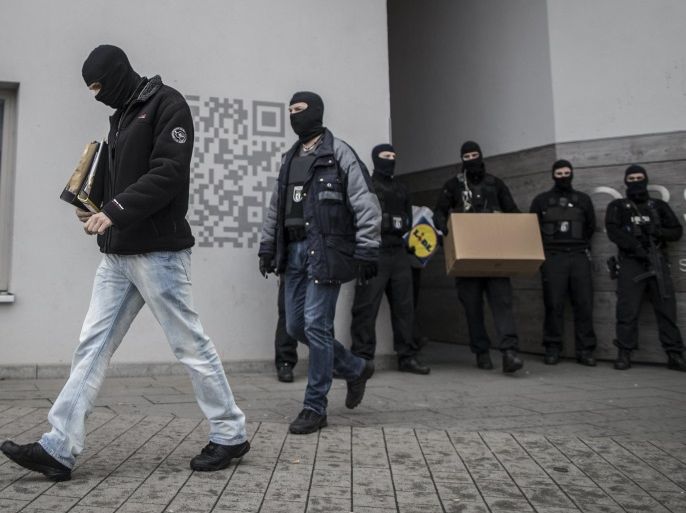 Masked police officers carry boxes out of an apartment building in Berlin, Germany, 28 February 2017. Police on early 28 January 2017 raided 24 places in Berlin, including apartments, businesses and six prison cells, in connection with the prohibition of the mosque association 'Fussilet 33 e.V.'. The Berlin Christmas Market attacker Anis Amri is said to have regularly visited the mosque.