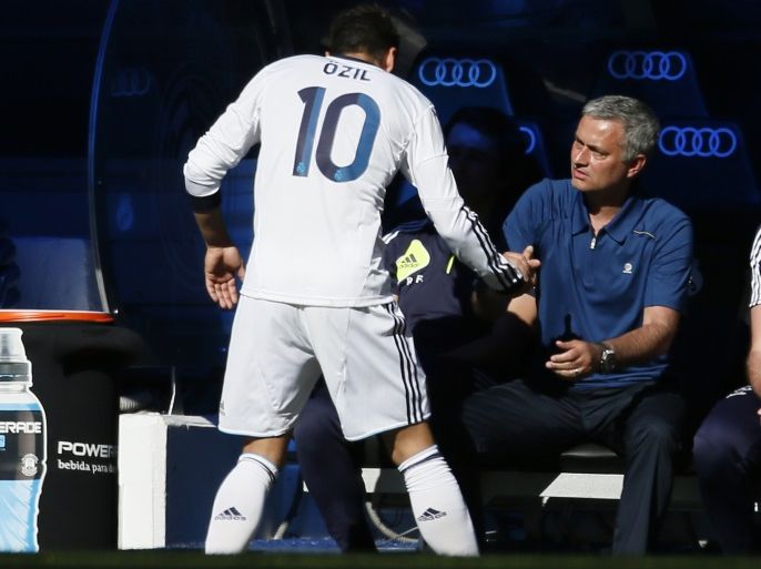 Real Madrid's Mesut Ozil celebrates a goal with his coach Jose Mourinho during their Spanish first division soccer match against Osasuna at Santiago Bernabeu stadium in Madrid June 1, 2013. Jose Mourinho ended his three-year reign as Real Madrid coach with a 4-2 win over Osasuna in La Liga on Saturday in a match where he was cheered and whistled in equal measure by a two-thirds full Bernabeu. The 50-year-old has agreed by mutual consent to leave the team, despite having three years left on his contract, and is widely expected to return to his former club Chelsea. REUTERS/Javier Barbancho (SPAIN - Tags: SPORT SOCCER)