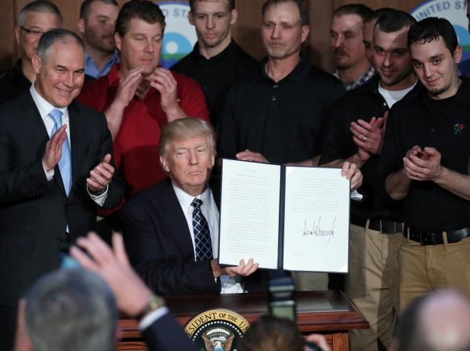 U.S. President Donald Trump holds up an executive order on