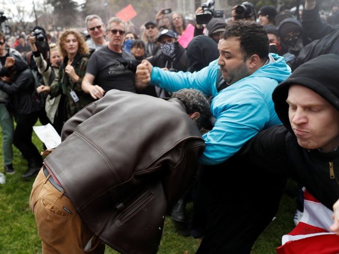 A demonstrator in support of U.S. President Donald Trump (L) scuffles with a counter-protester during a