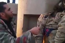 أحد مقاتلي حفتر يسخر من جثة قائد بشورى بنغازي
