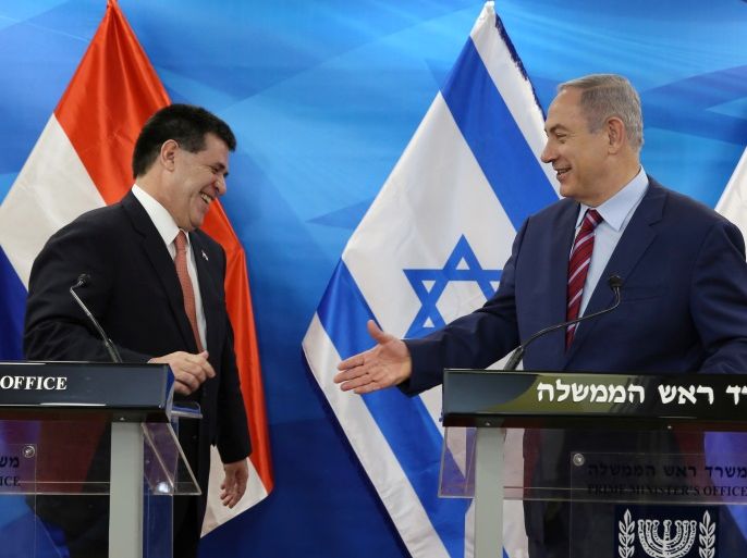 Israeli Prime Minister Benjamin Netanyahu (R) reaches out to shake hands with Paraguayan President Horacio Cartes as they meet at his Jerusalem office on July 19, 2016. REUETRS/GALI TIBBON/Pool