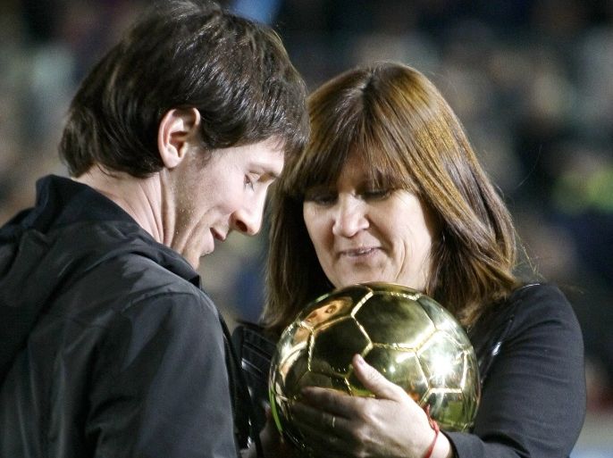 Celia, mother of Barcelona player Lionel Messi, gives the 2009 Ballon d'Or trophy to her son at Nou Camp...