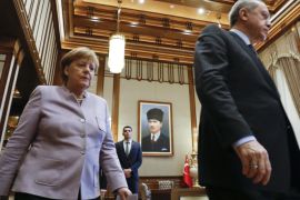 Turkish President Recep Tayyip Erdogan and German Chancellor Angela Merkel walk past a picture of Turkish Republic state founder Kemal Atatuerk before their bilateral meeting at the presidential palace during the first visit since July's failed coup in Ankara, Turkey, February 2, 2017. REUTERS/Umit Bektas